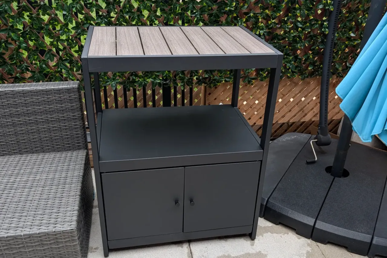 Patio storage cabinet assembled beside wicker patio seating